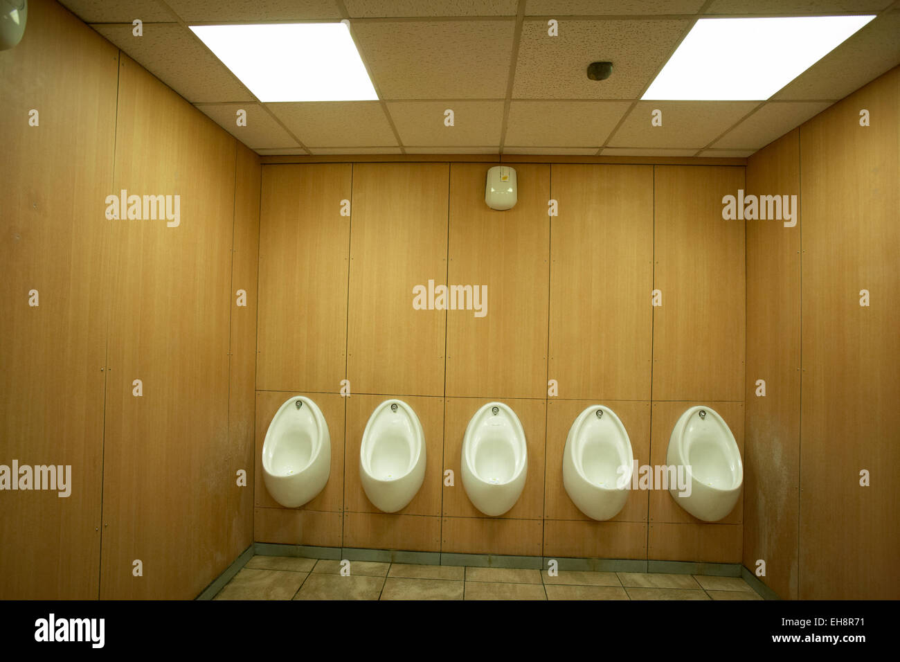 Fünf weiße Urinale in einer Herrentoilette UK Stockfoto