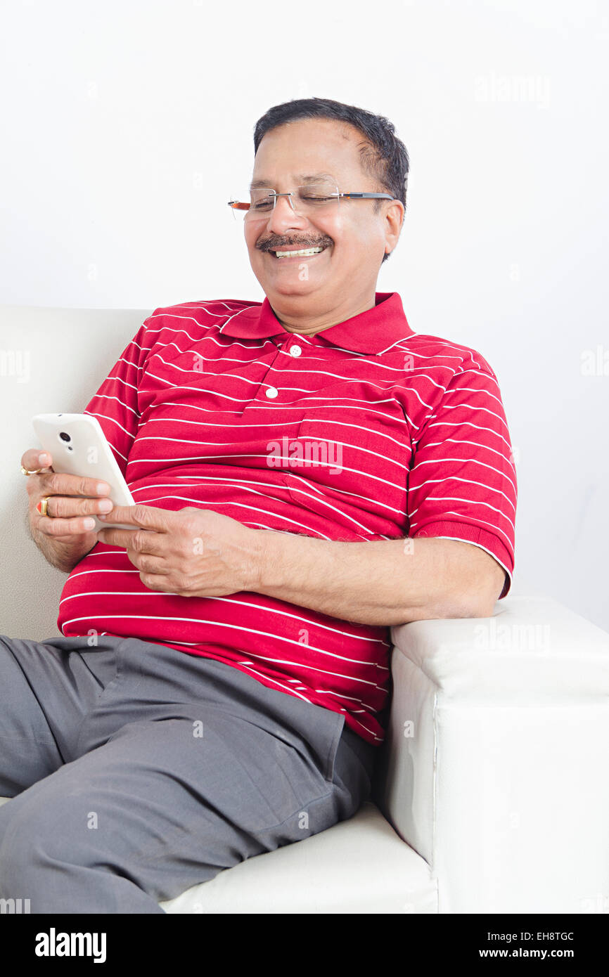1 indische Senior erwachsenen Mann sitzen Sofa Einwahl Handy Stockfoto