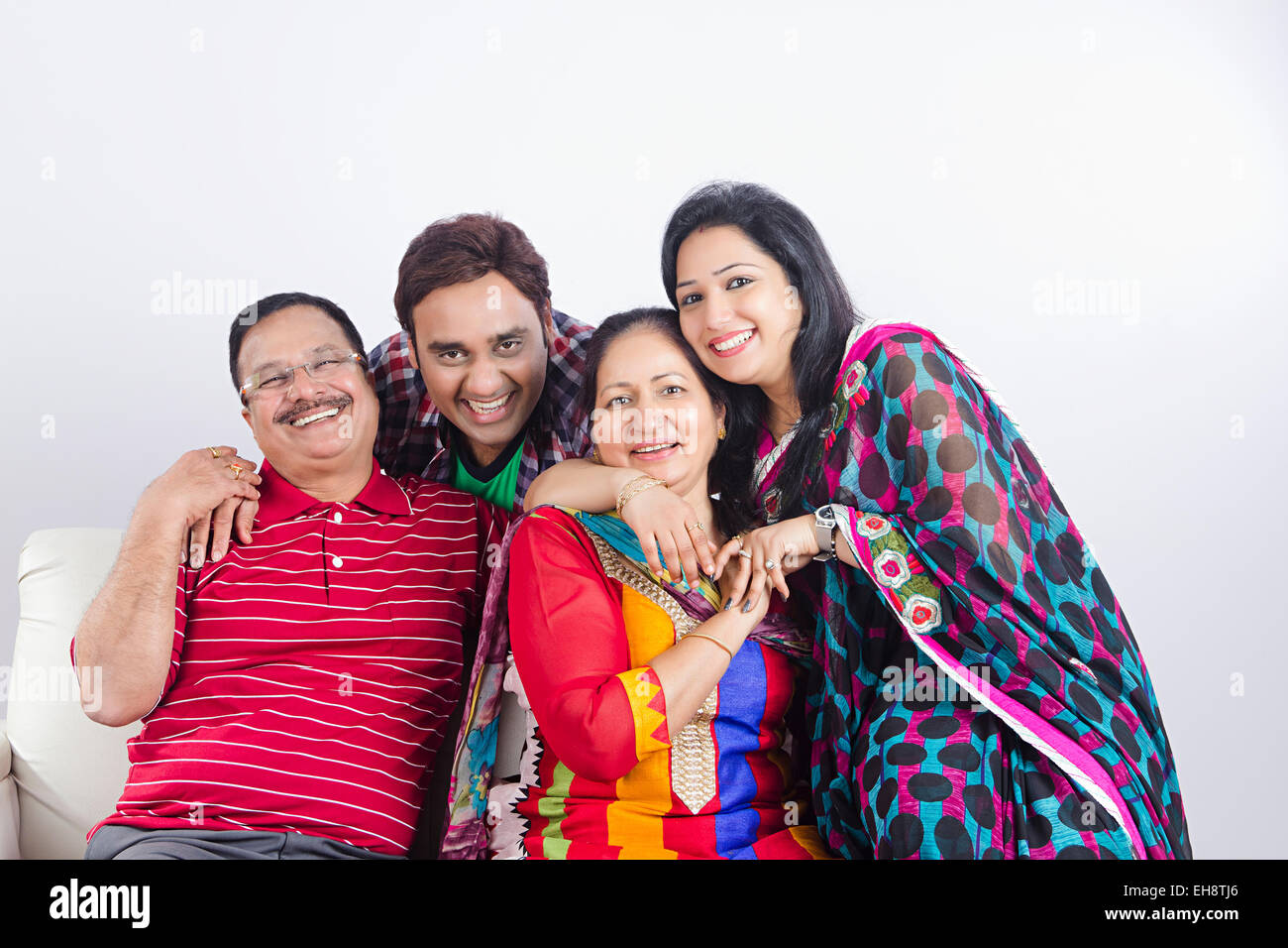 4 indische Erwachsene Eltern Sohn und Schwiegertochter sitzen sofa Stockfoto