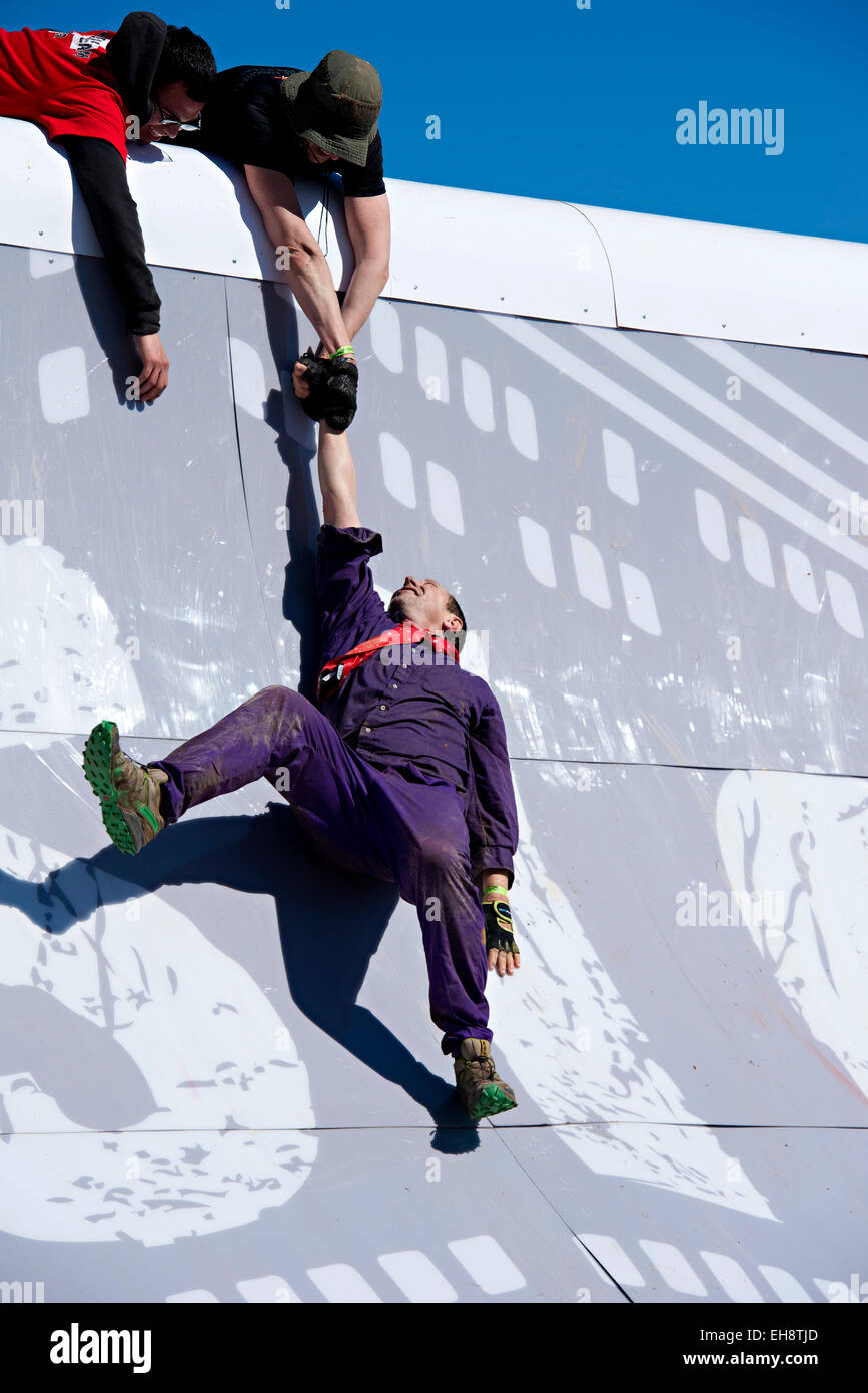 Man gleitet Mauer nach dem Versuch zu laufen, die Wand als Teil der Tough Mudder-Veranstaltung in Milton, Florida Stockfoto