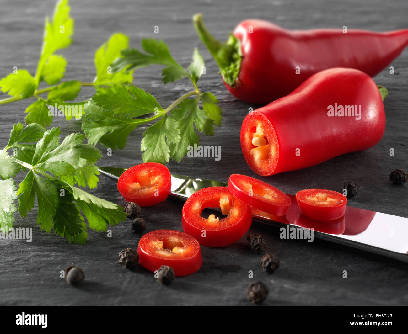 Frische rote Chilis ganze & Cut mit frischen Korianderblättern. komponierte Anordnung Stockfoto