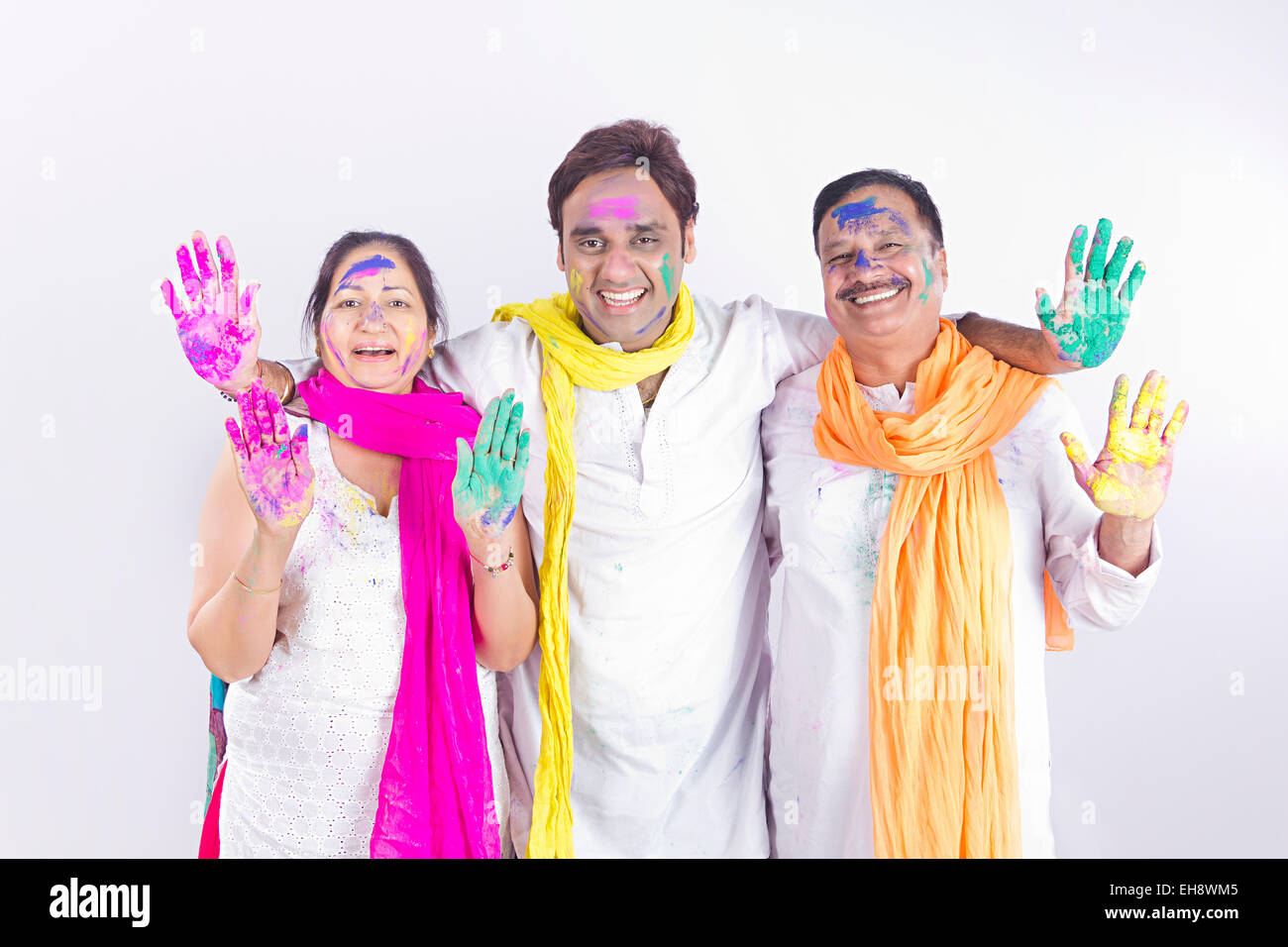 3 indische Erwachsene Eltern und Sohn Holi Festival hand zeigen Stockfoto
