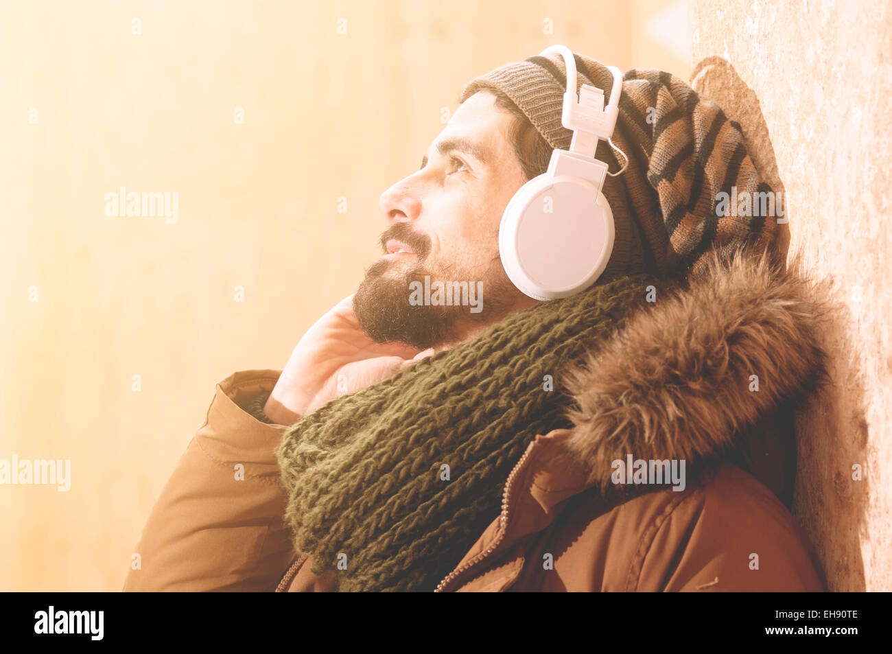 ein junger Mann hört Musik in einem städtischen Bild des modernen Lebensstils Instagram getönt Stockfoto