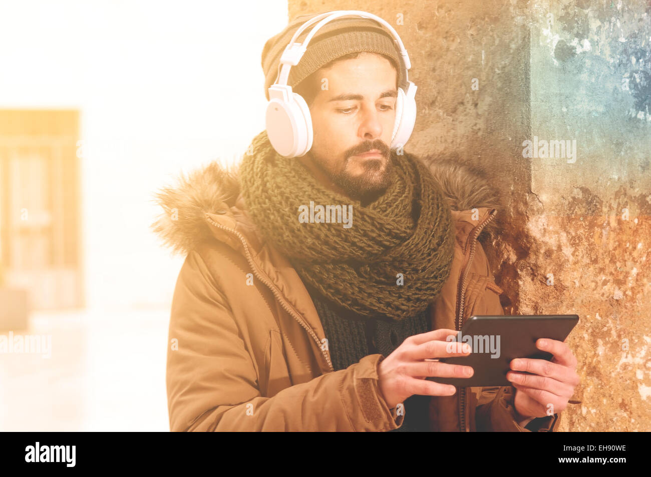 junger Mann hält eine Tablette in städtischen im Freieneinstellung Warmton-Filter angewendet Stockfoto