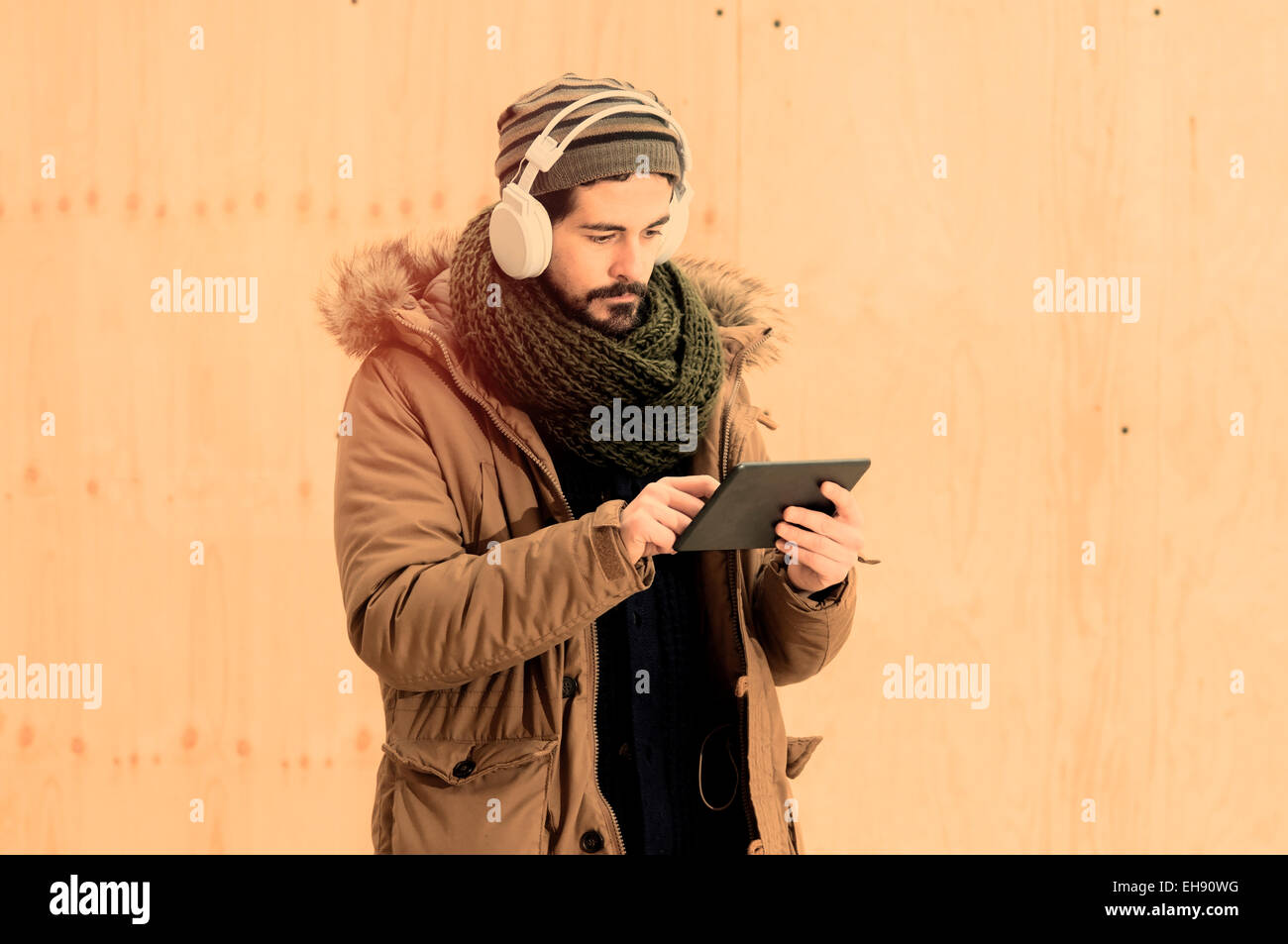 junger Mann hält eine Tablette in städtischen im Freieneinstellung Warmton-Filter angewendet Stockfoto