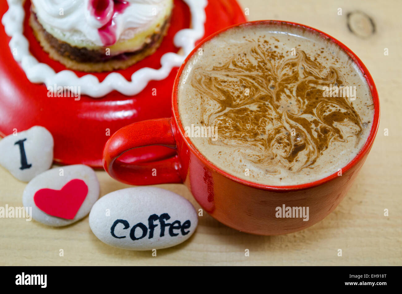 Rote Tasse Kaffee mit dekorierten Schaum und Kieselsteinen, die sagen: "Ich liebe Kaffee" Stockfoto