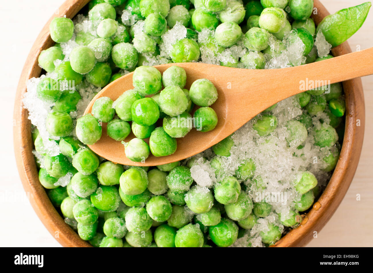 Gefrorene grüne Erbsen mit Stücken der Hülsen mit Frost bedeckt Stockfoto