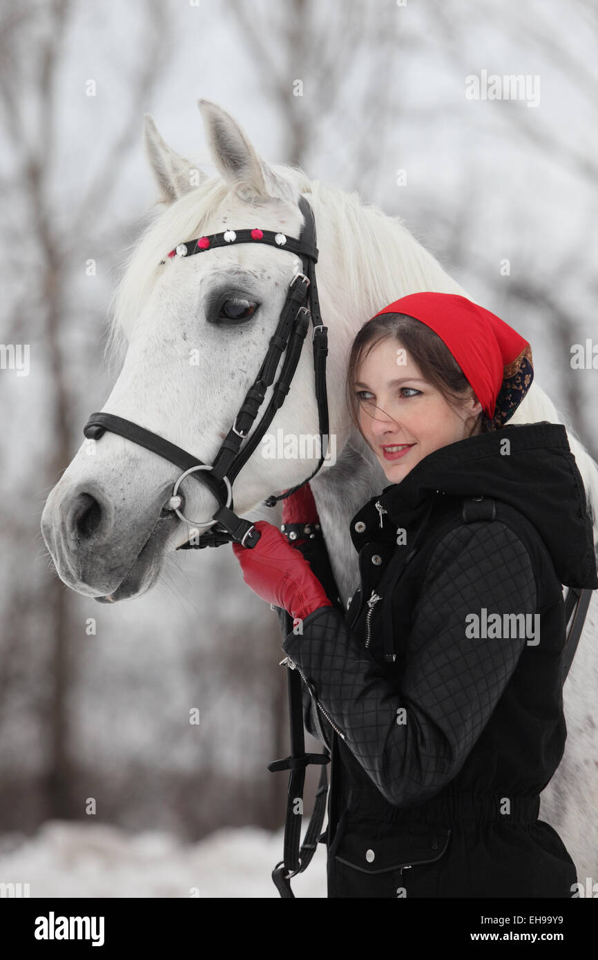 Pferd und hübsche Brünette Frau in Winterlandschaft Stockfoto