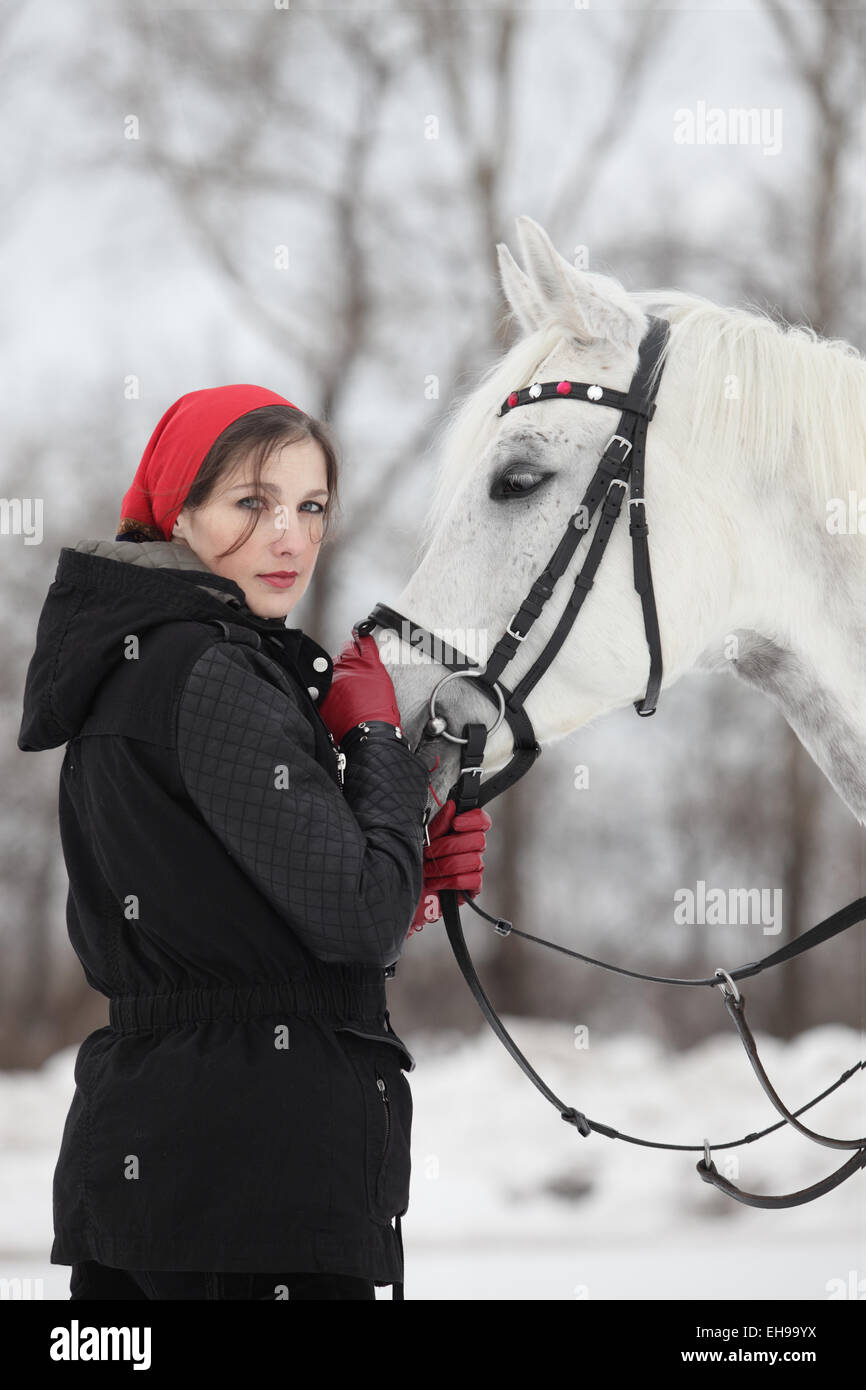 Pferd und hübsche Brünette Frau in Winterlandschaft Stockfoto