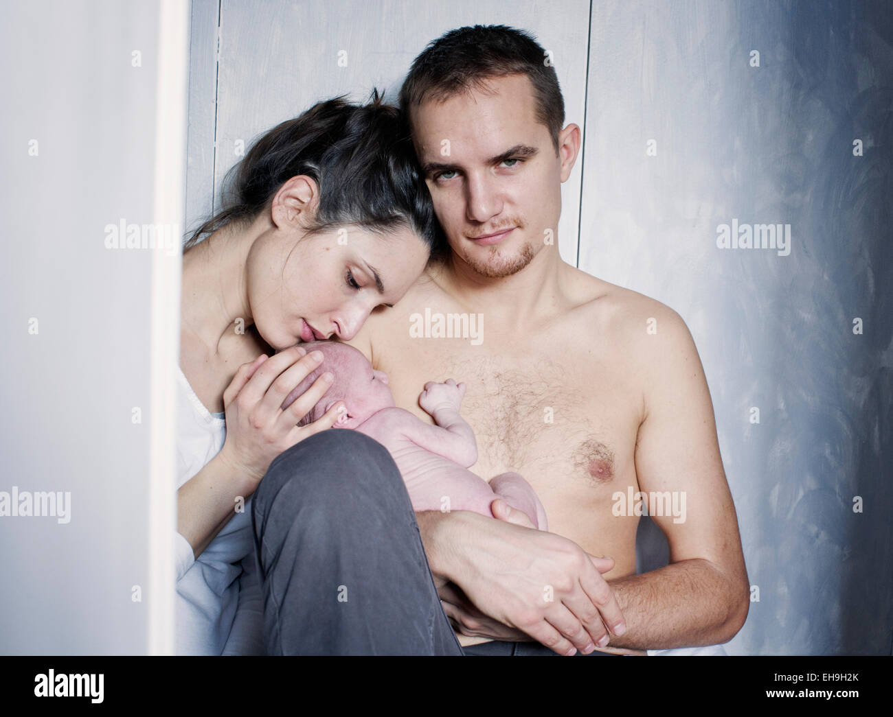 Neue Eltern mit Neugeborenen Baby sitzen Stockfoto