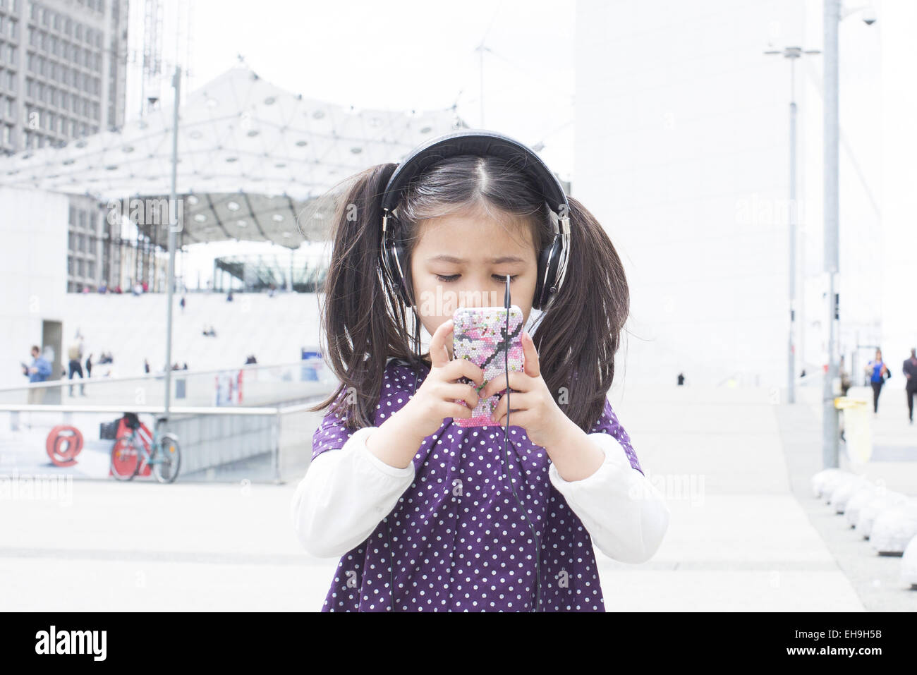 Mädchen Smartphone betrachten und anhören von Kopfhörer im freien Stockfoto