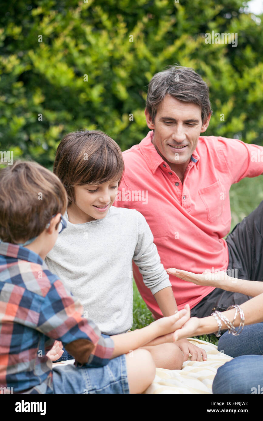 Jungs spielen Handspiel mit Familie Stockfoto