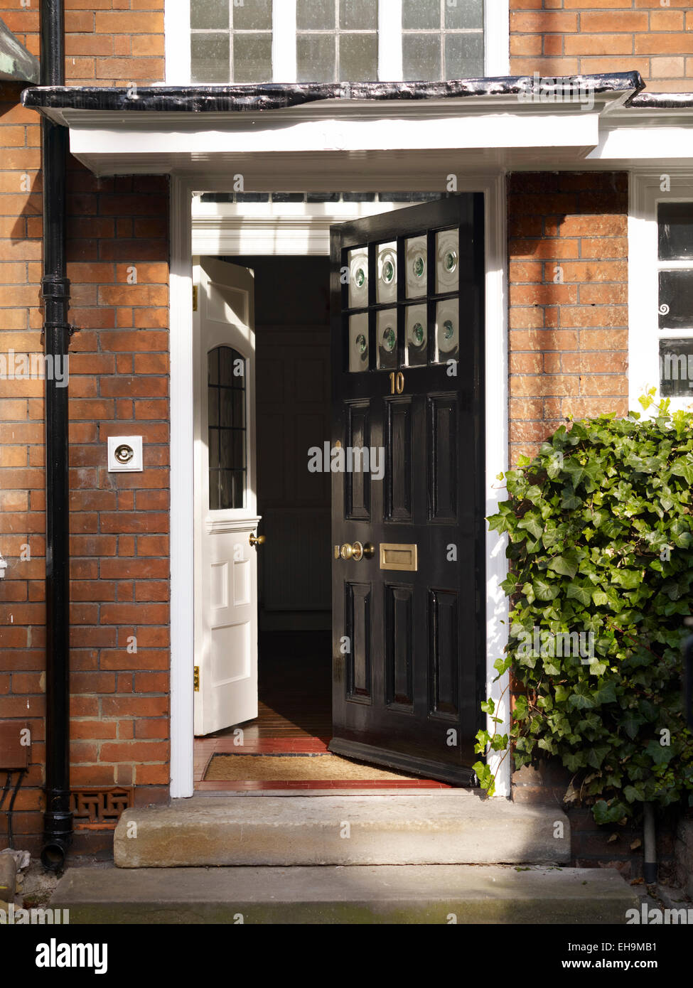 Traditionelle Schwarz Front Tür öffnen der Backsteingotik Wohnhaus, Kingsmead, UK Stockfoto