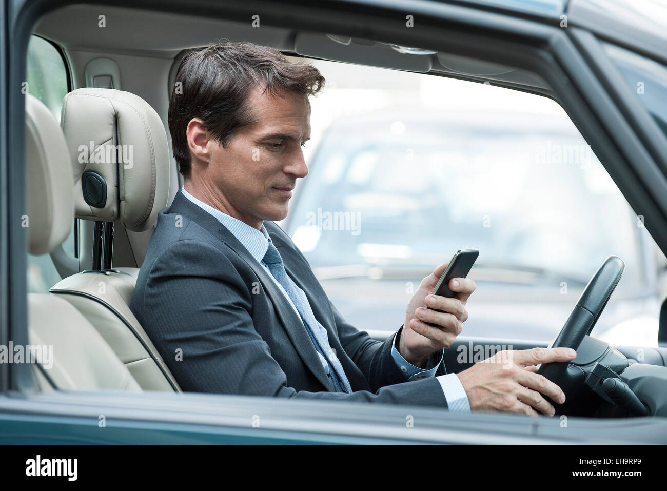 Mann am Handy während der Fahrt Stockfoto