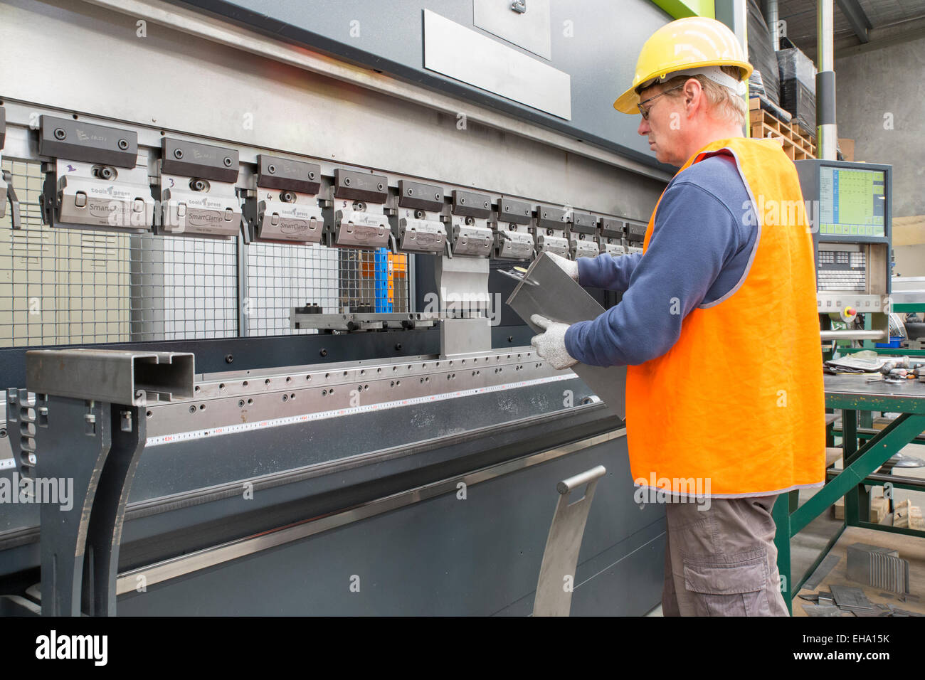 Metallindustrie Arbeiter prüft gefalteten Blechteil. Stockfoto