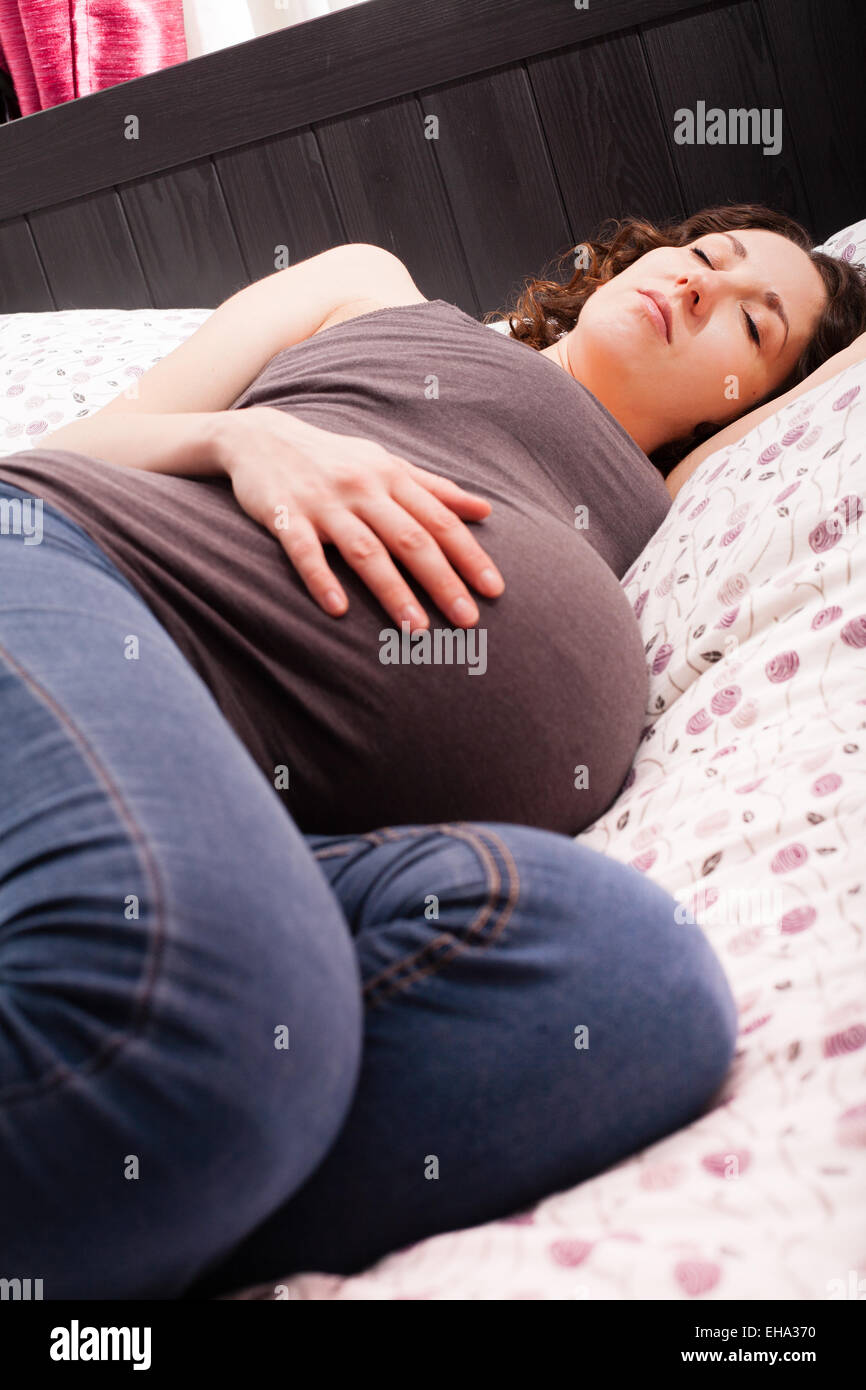 Volle Amtszeit schwanger Frau schläft. Stockfoto