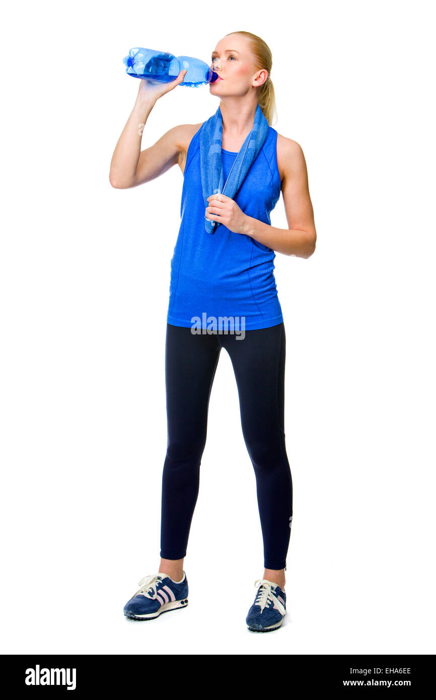 Frau trägt Fitnesskleidung und Trinkwasser Stockfoto