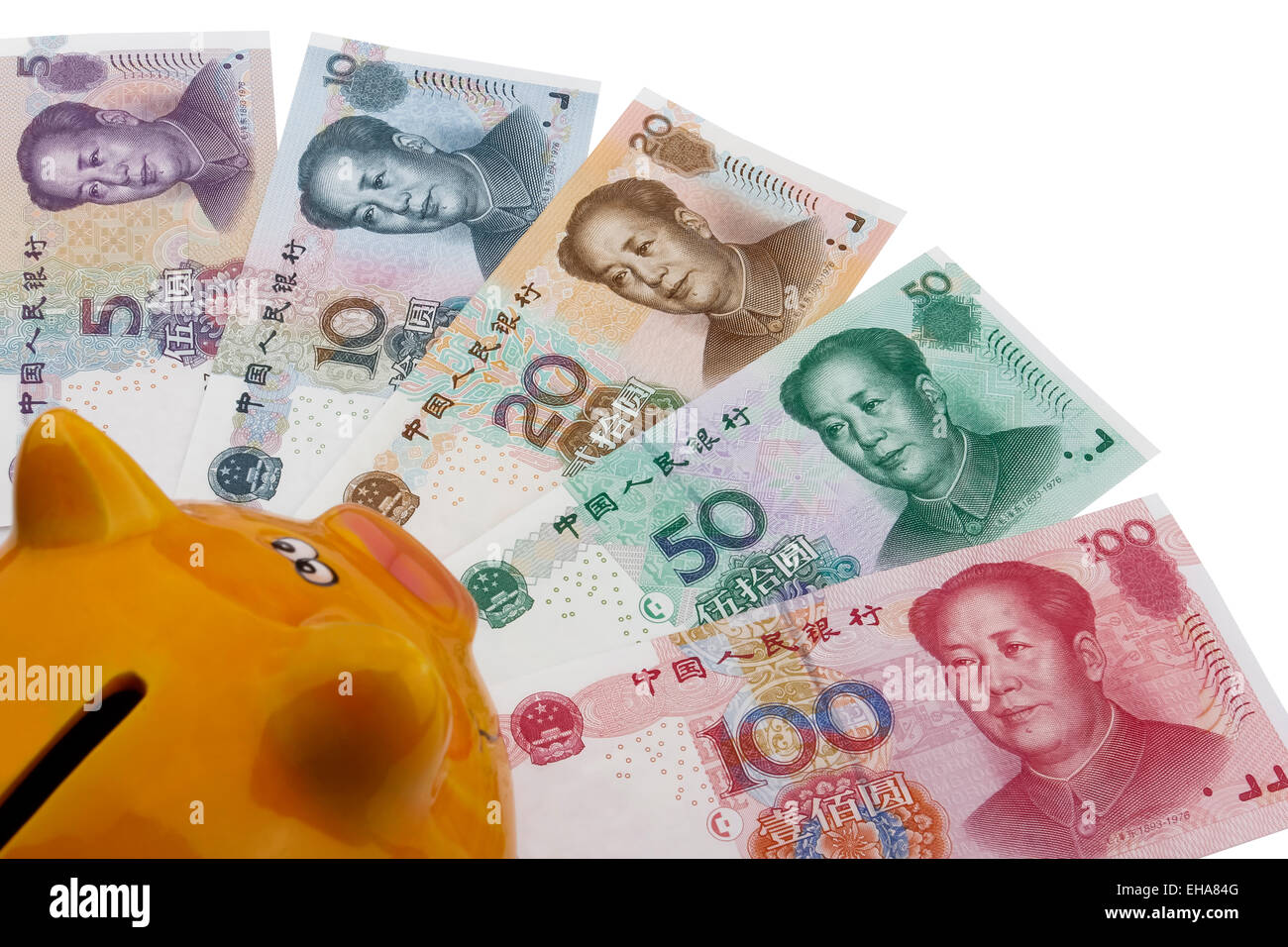 Chinesisches Geld (RMB) und ein Sparschwein auf weißem Hintergrund. Stockfoto