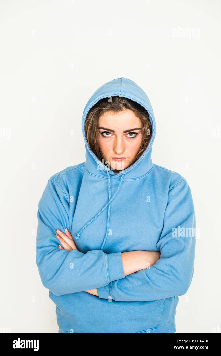 Eine stimmungsvolle 13 14 15 jährige junge Teenager-Mädchen tragen eine  blaue Kapuzenjacke Hoodie Schweiß Shirt stehen gegen eine reine weiße  Studio-Hintergrund UK Stockfotografie - Alamy
