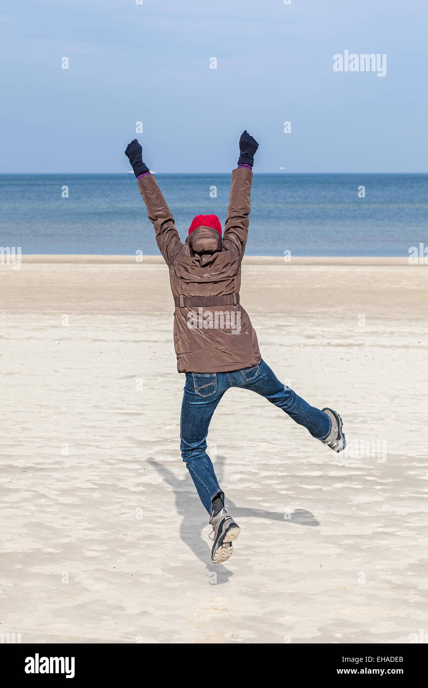 Frau am Strand, Winter aktiven Lifestyle-Konzept springen. Stockfoto