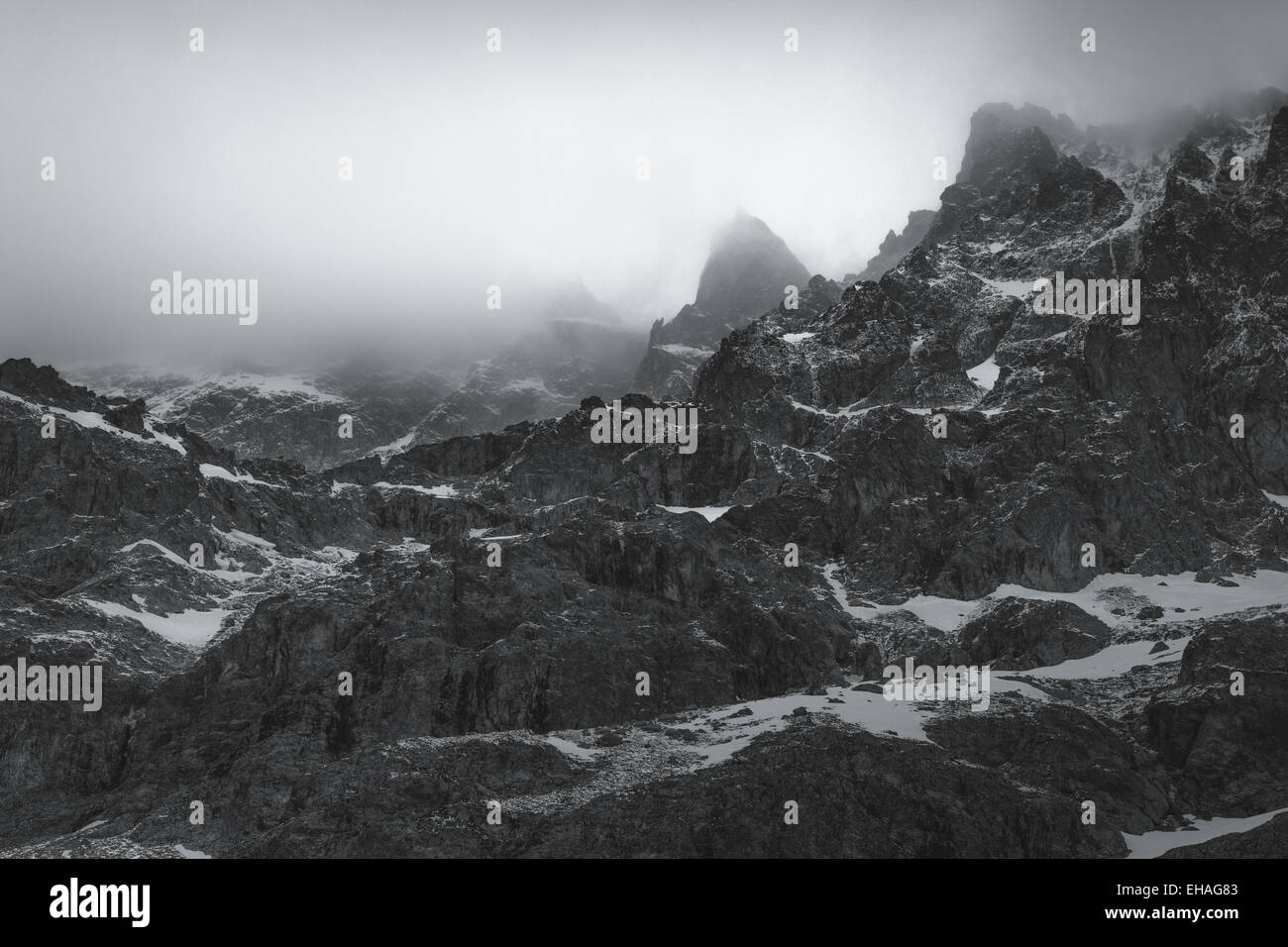 Schwarz und weiß: gezackte Gipfel in dicke Wolke auf der Südseite des Berges Barre des Ecrins, Französische Alpen. Stockfoto