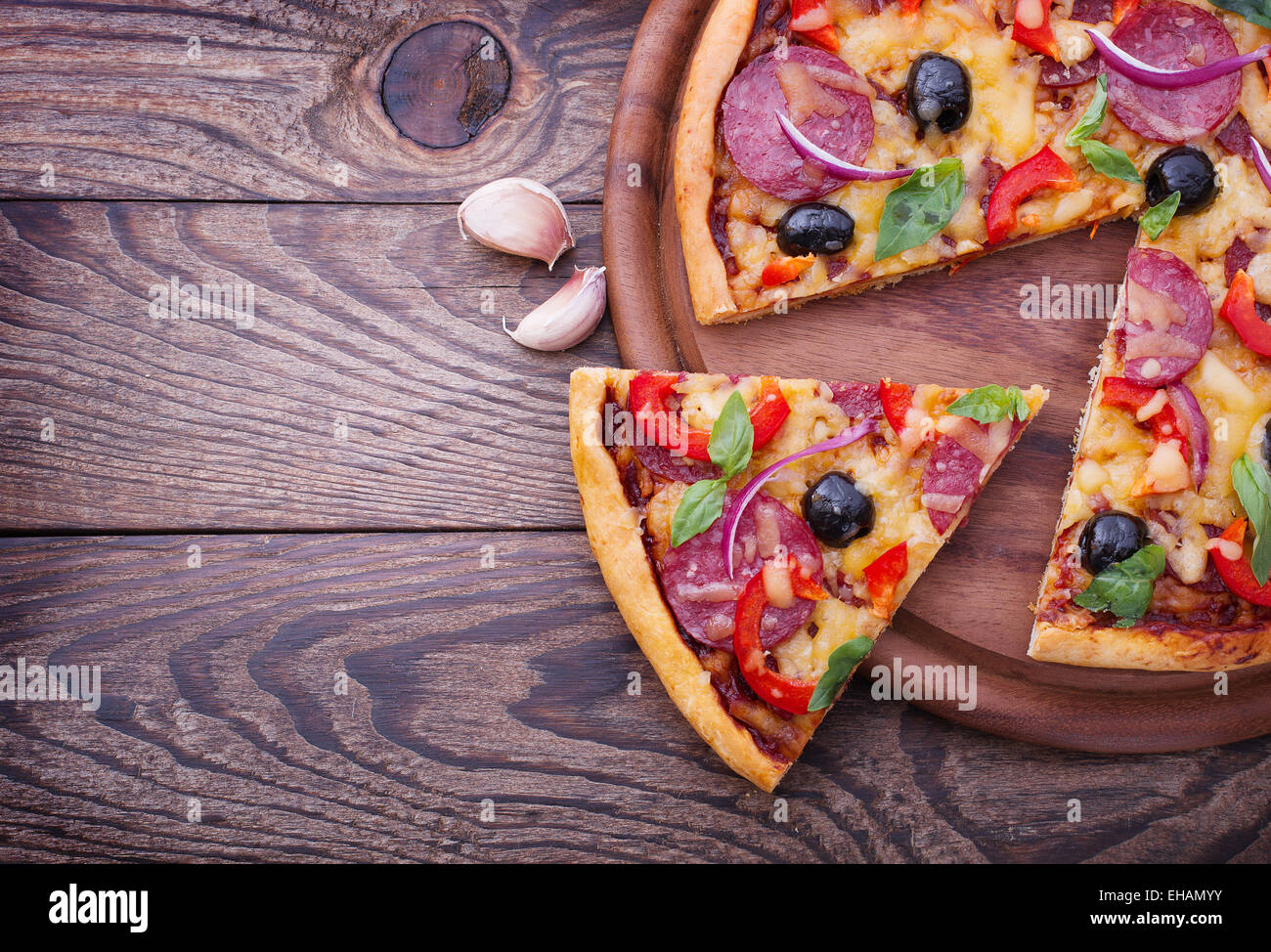 Pizza mit Tomaten, Salami und Oliven Stockfoto