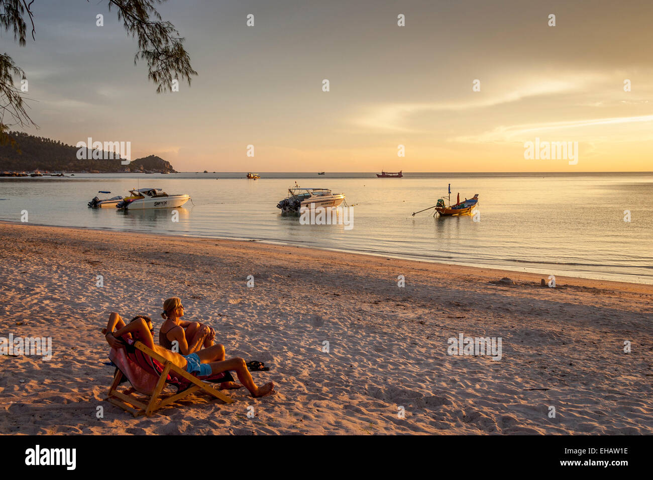 Ein paar beobachten den Sonnenuntergang am Hut Sairee Beach, Ko Tao, Thailand Stockfoto