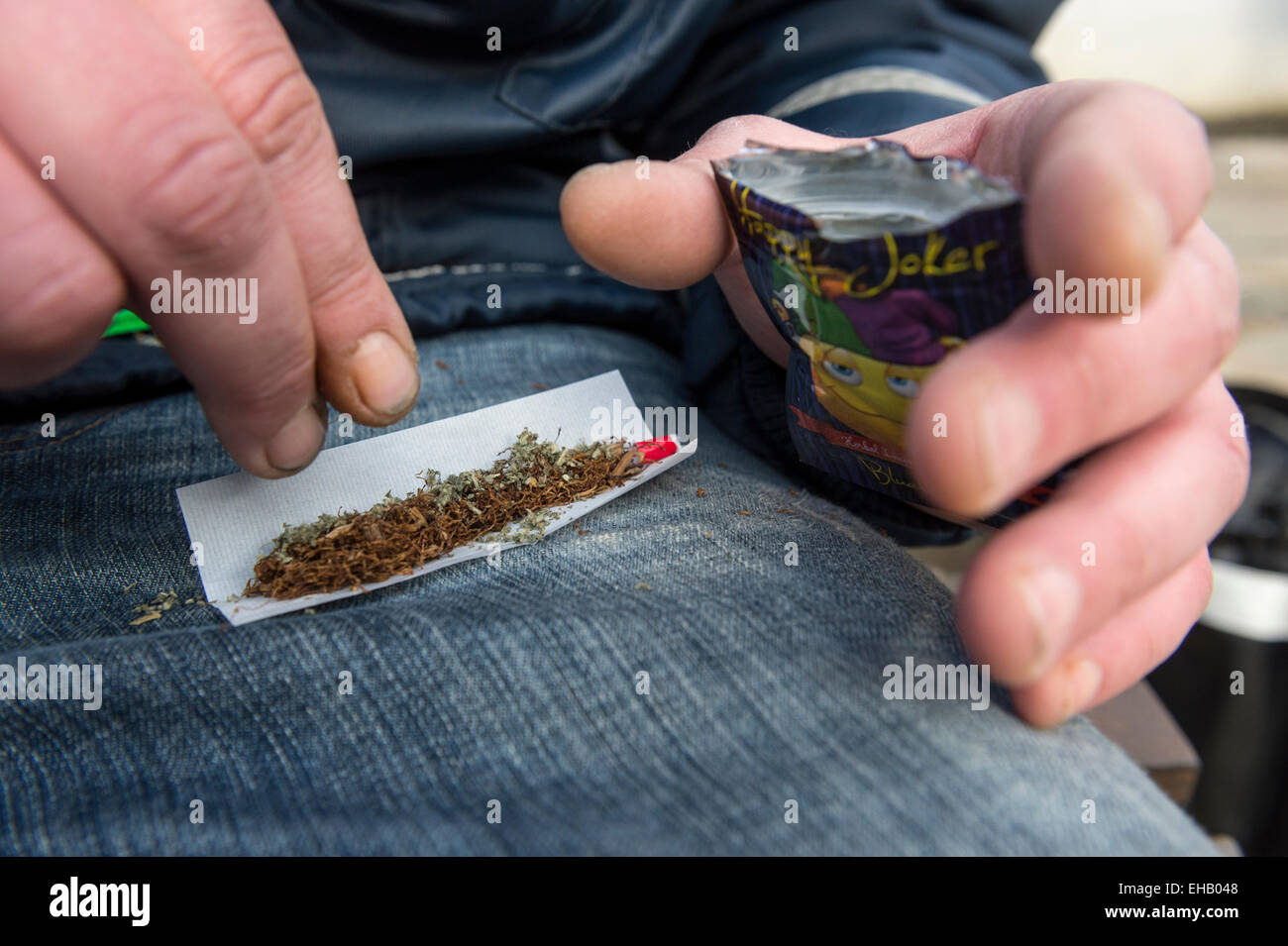 Ein Mann, der einen Joint mit Happy Joker, Legal High Stockfoto