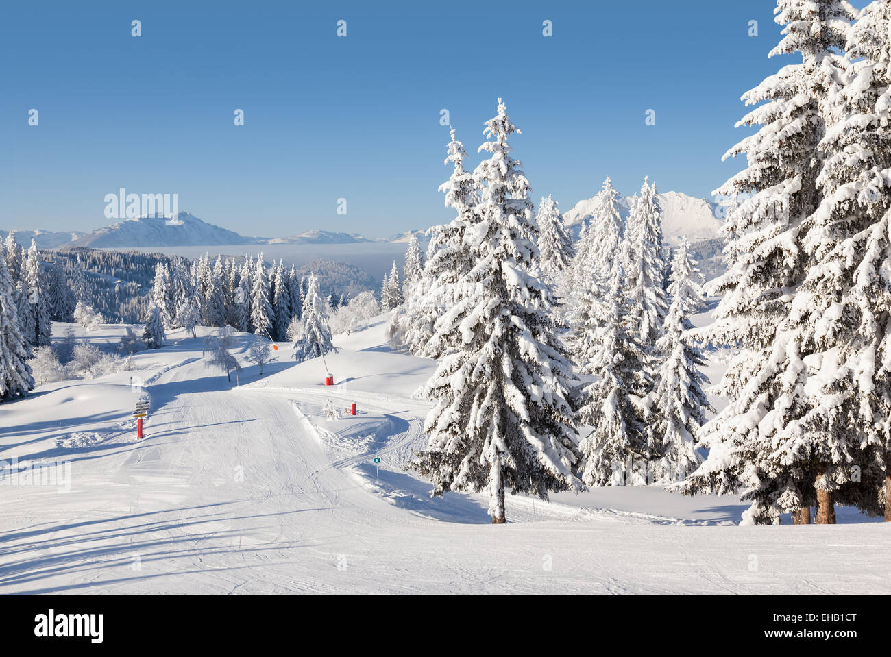 Winter-Blick auf eine leere Skipiste in Les Gets - Teil des Skigebiet Portes du Soleil, Frankreich. Stockfoto