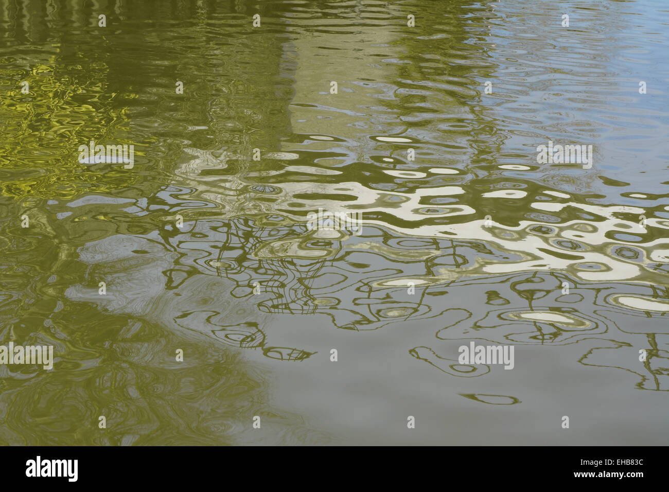 Wasserwellen und gebrochene Spiegelungen auf der Oberfläche eines grün-Flusses, einen abstrakten Hintergrund bilden Stockfoto