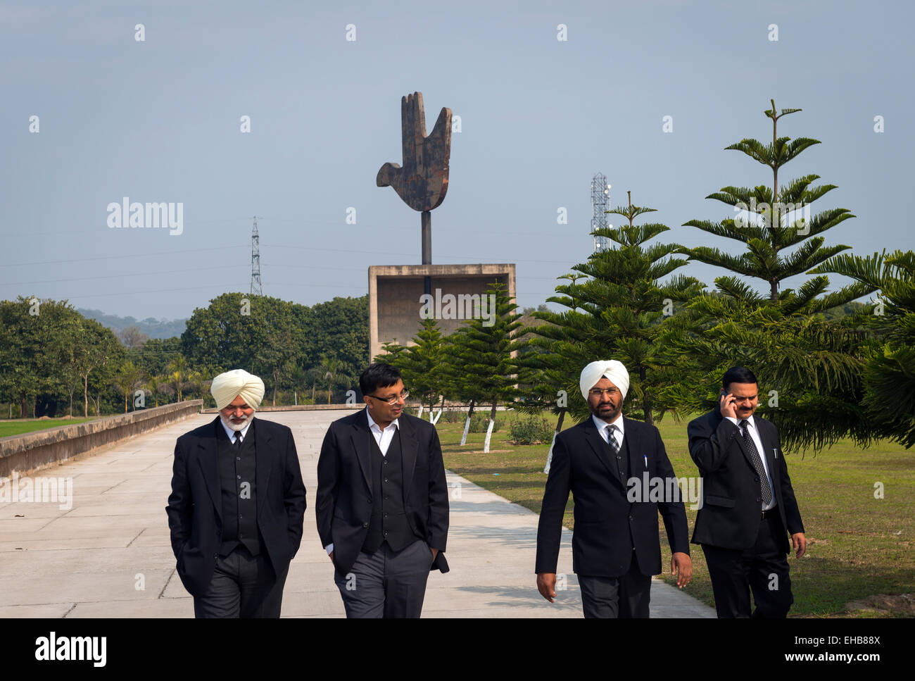 Indische Anwälte oder Juristen in der Nähe von Le Corbusiers offene Hand-Symbol in der Nähe der High Court in Chandigarh, Indien. Stockfoto