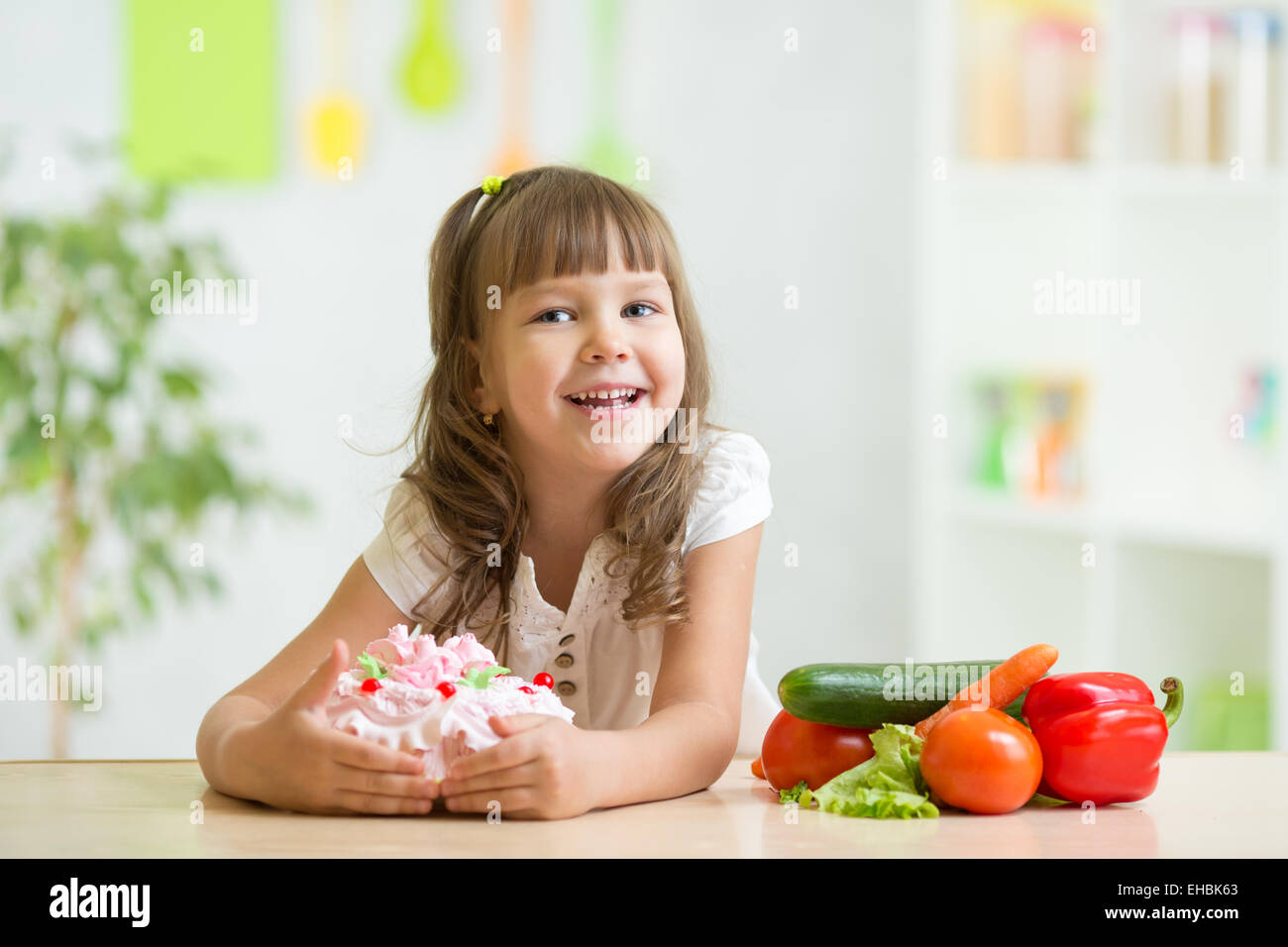Kind, süße Kuchen anstatt gesundes Gemüse Auswahl Stockfoto