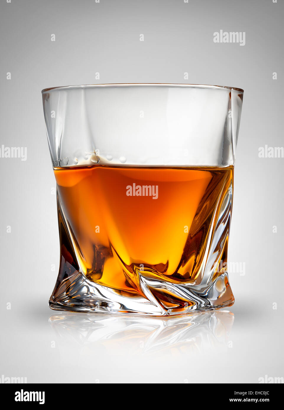 Glas Cognac auf grauem Hintergrund Stockfoto