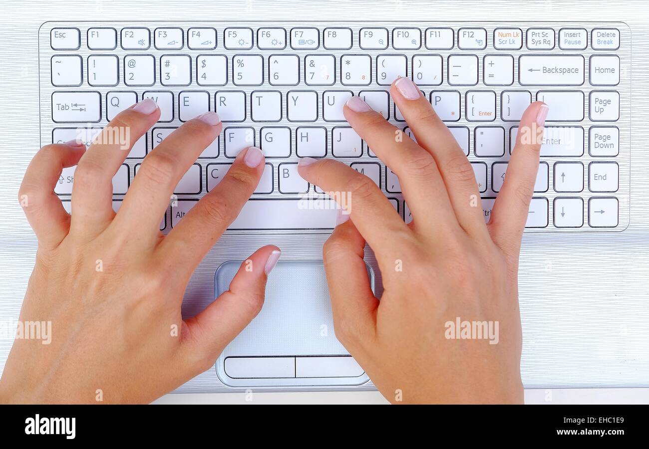 Tastatur Typing.female SMS auf einer weißen Laptoptastatur Stockfoto
