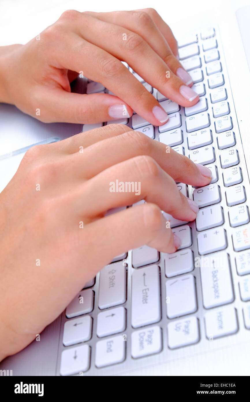 Tastatur Typing.female SMS auf einer weißen Laptoptastatur Stockfoto