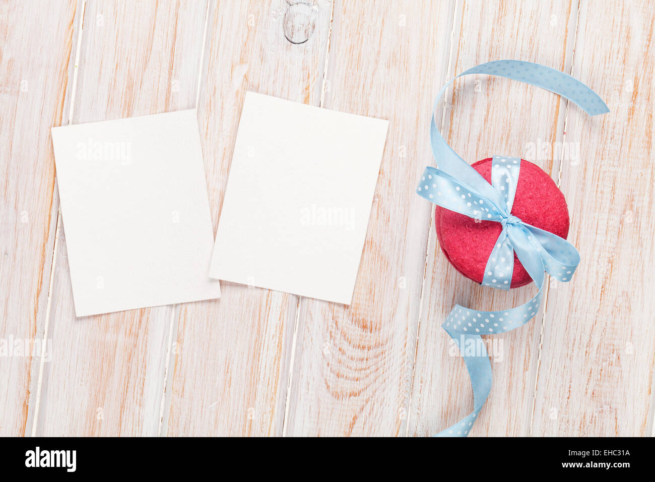 Digitale Bilderrahmen oder Grußkarten und Macarons mit Band über weißem Holz Hintergrund Stockfoto