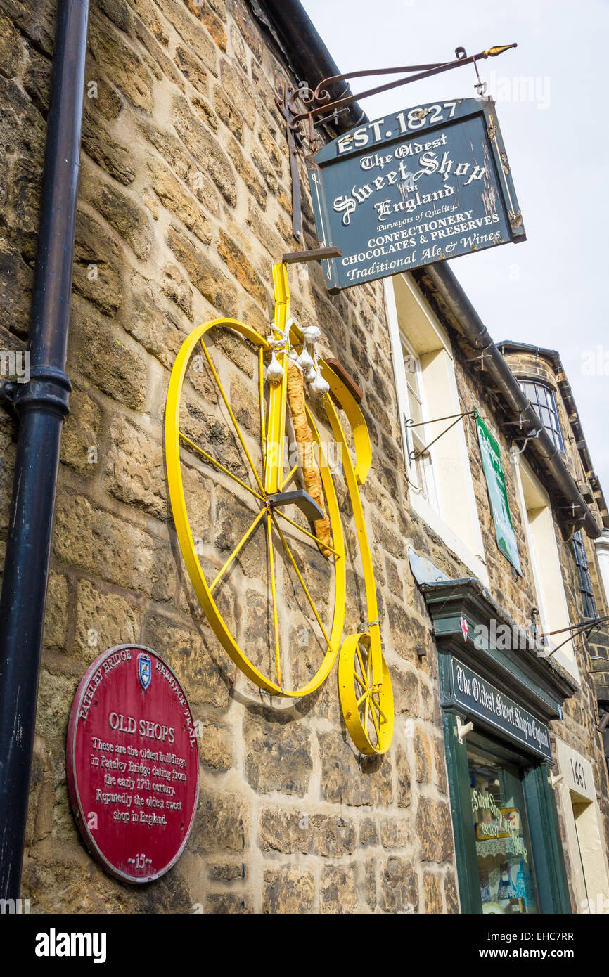 Ein gelbes Fahrrad Strecke der Tour De France zu markieren hing außerhalb der ältesten Sweet Shop in der Welt in Pately Bridge, Yorkshire Stockfoto