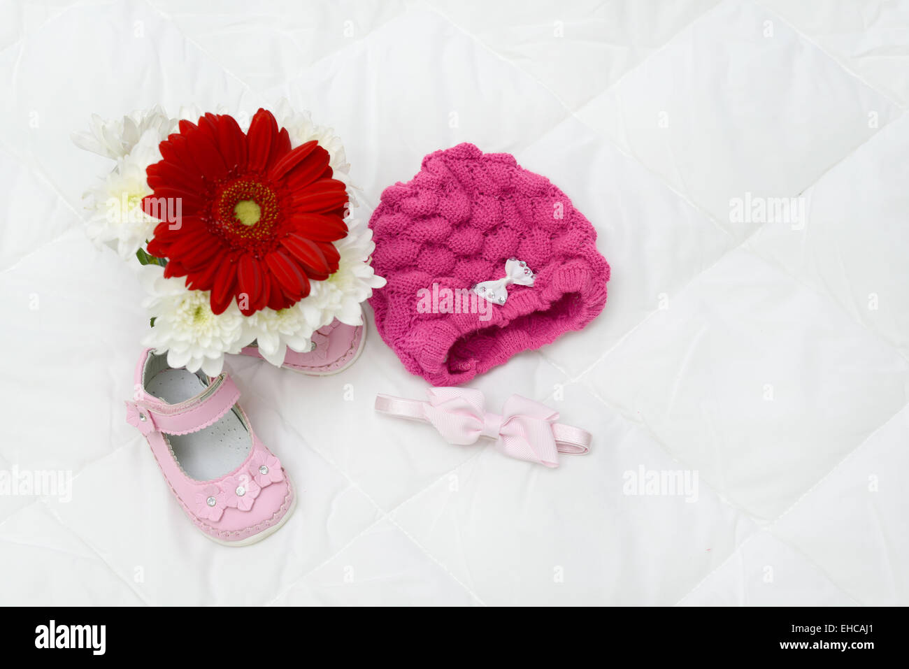 Gerbera-rosa Baby-Schuhe und Kopfbedeckung rosa in natürlichem Licht Stockfoto