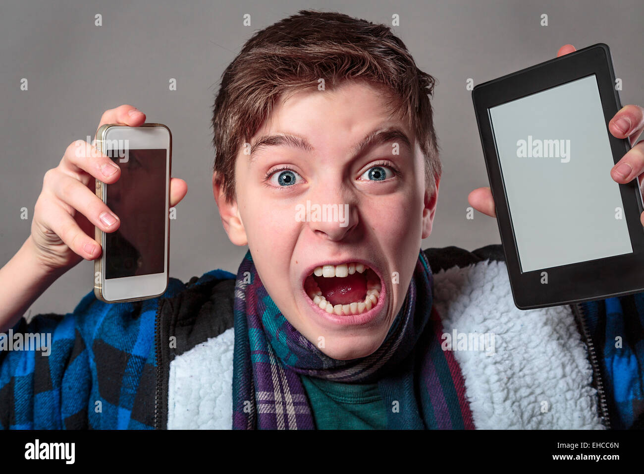 Teenager bekommt verrückt mit digitalen Medien, grauen Hintergrund für die schnelle Isolierung Stockfoto