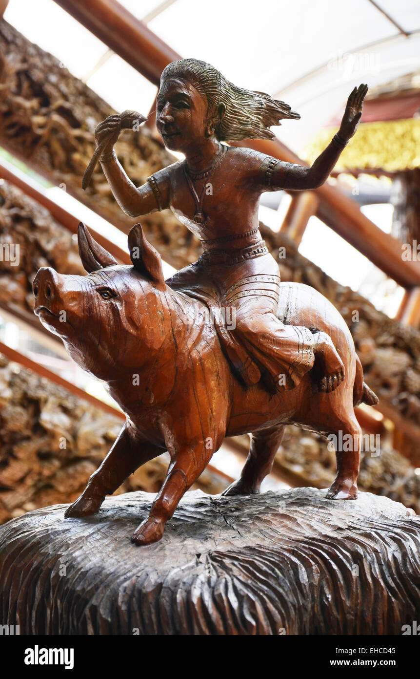 Traditionellen Thai-Stil Holzschnitzerei als Frau Reiten Schwein eines der 12 Tierkreiszeichen in der Kirche von Tempel in Thailand. Stockfoto