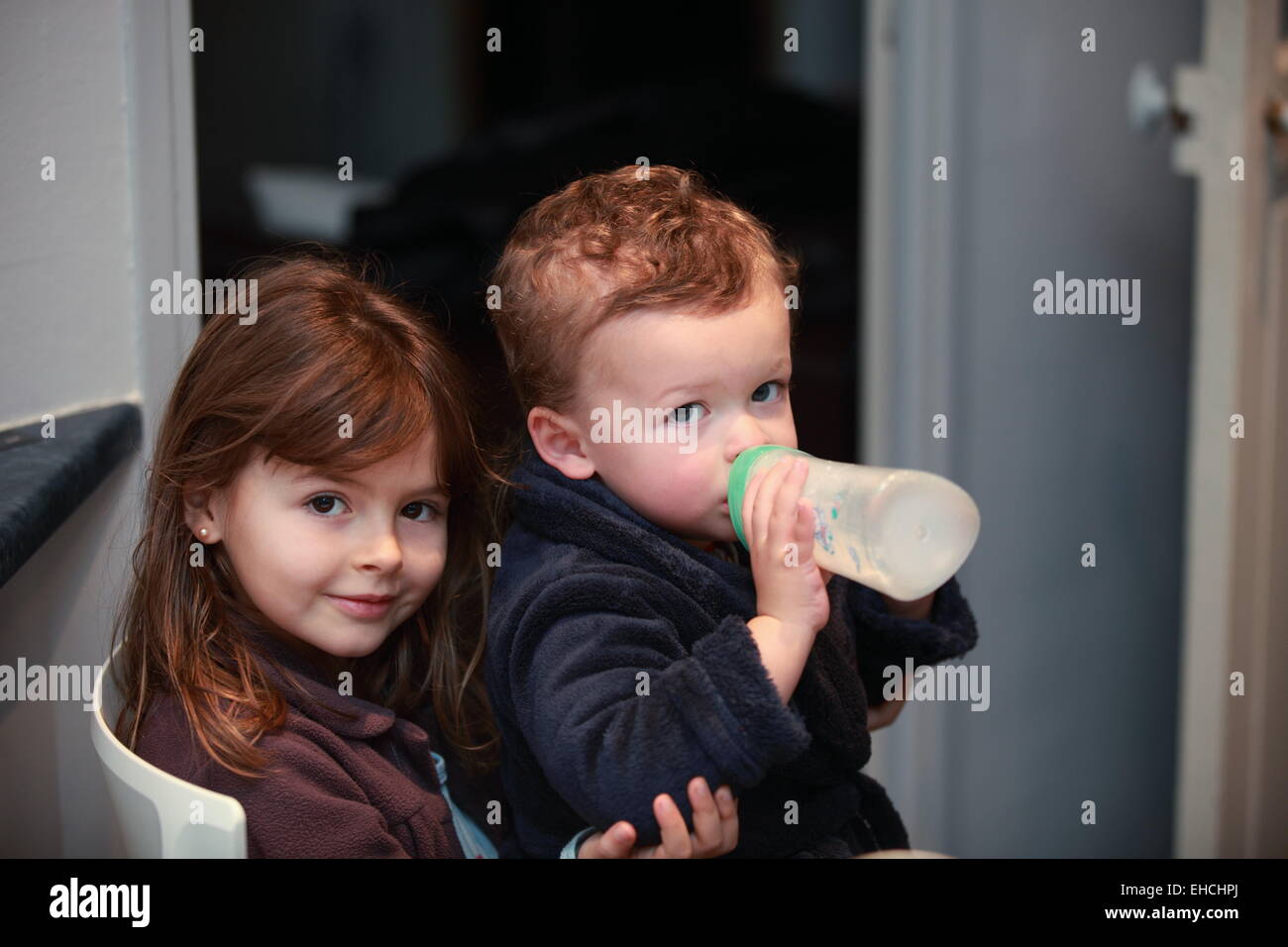 Bruder und Schwester Trinkmilch mit Babyflasche. Stockfoto