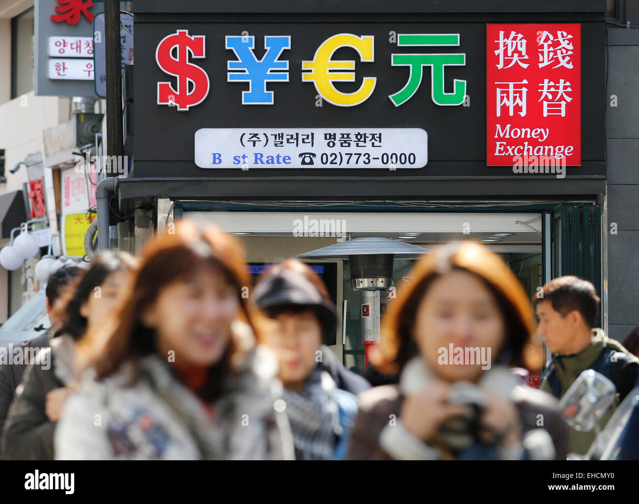 Wechselkurs, 12. März 2015: Menschen gehen vorbei an eine Wechselstube in zentralen Seoul, Südkorea. Die Bank of Korea brachte am Donnerstag den Leitzins auf ein Rekordtief von 1,75 Prozent führt zu einer Schwächung des Won. © Lee Jae-Won/AFLO/Alamy Live-Nachrichten Stockfoto