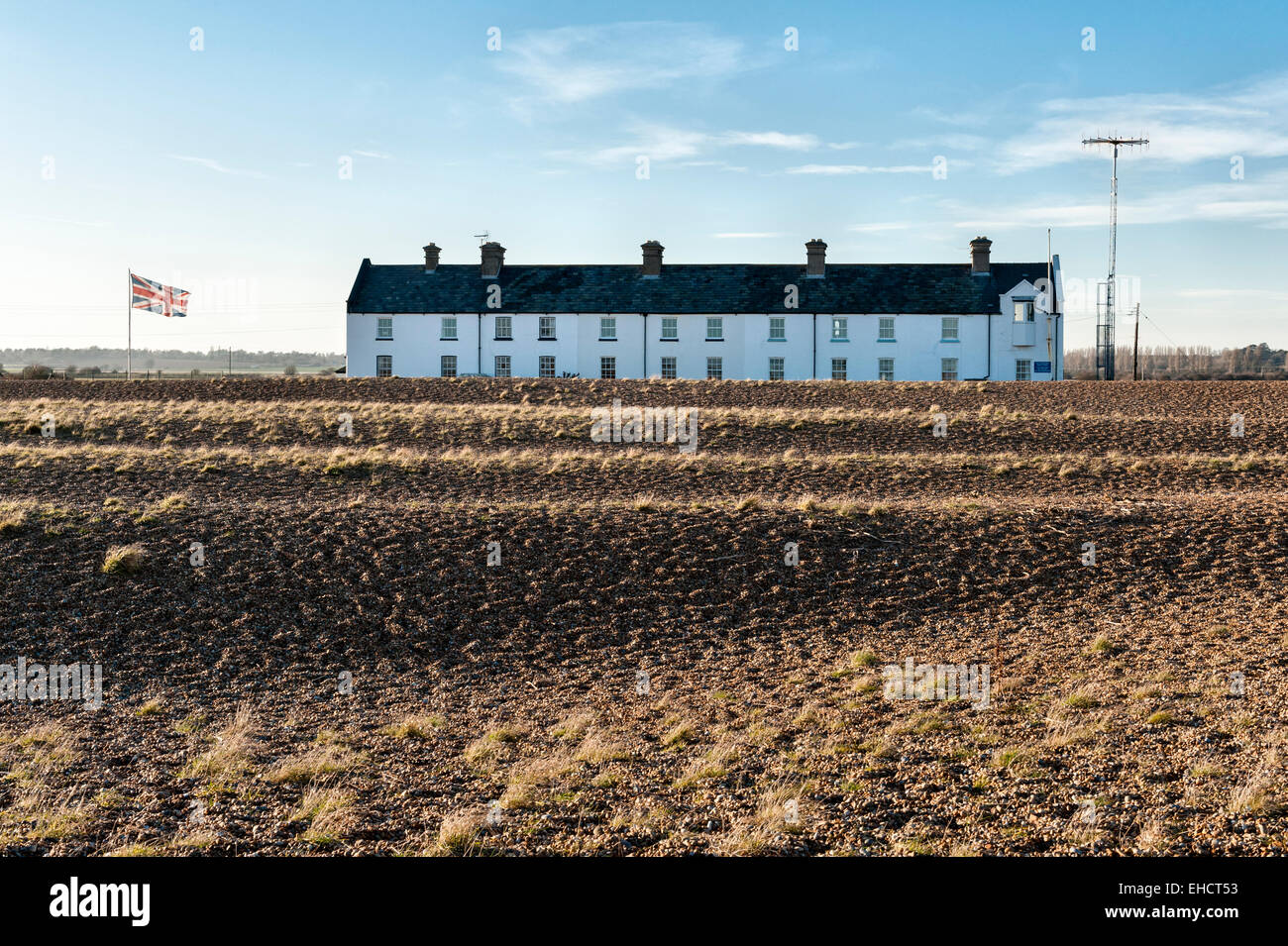 Eine Reihe alter Cottages der Küstenwache im abgelegenen Dorf Shingle Street, Suffolk, an der britischen Ostküste. Ein Kommunikationsturm befindet sich auf der rechten Seite Stockfoto