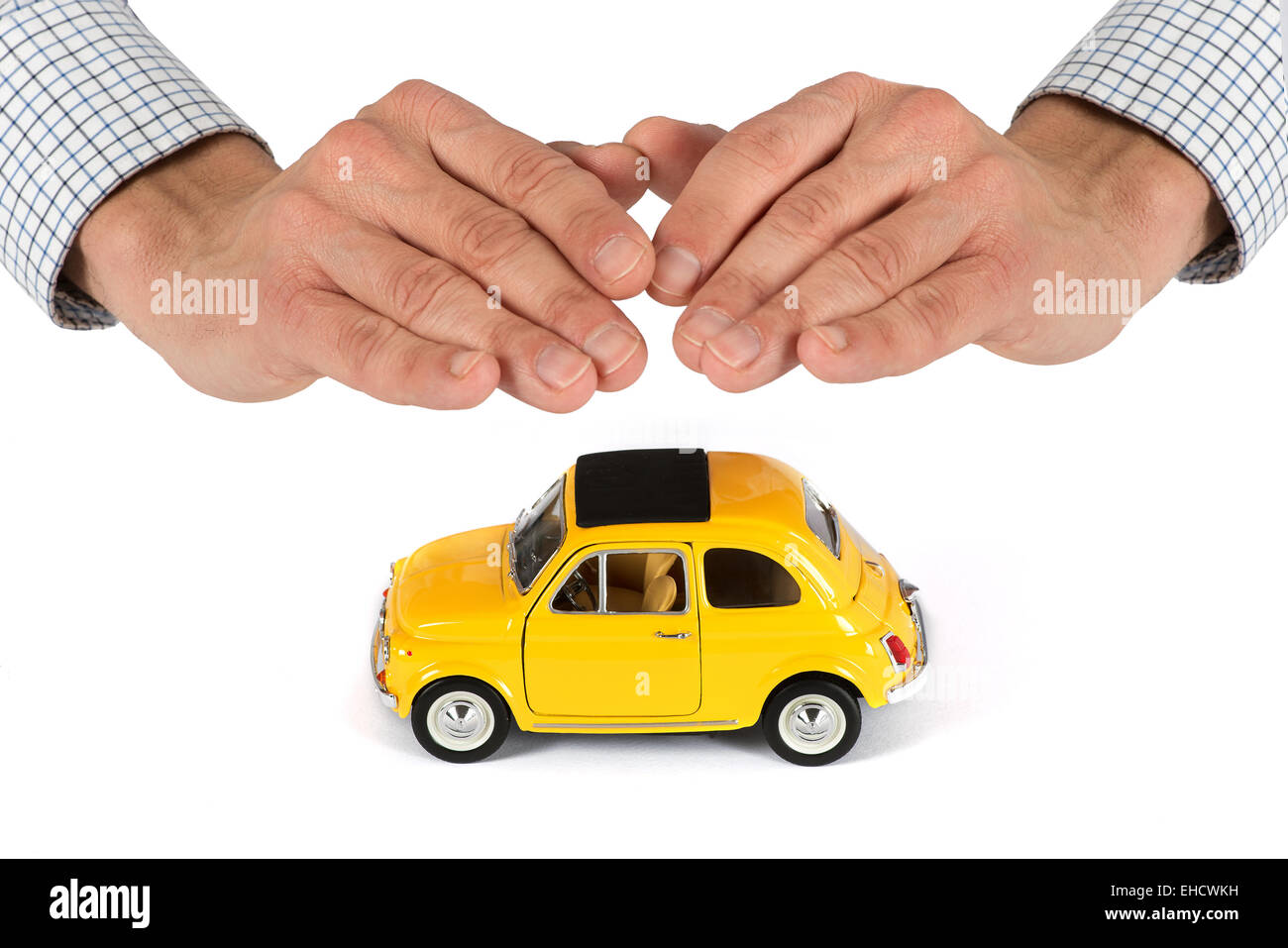 Erwachsene männliche Hände mit Schutzabdeckung Überoberseite des gelben Spielzeugauto, Versicherungskonzept Bild Stockfoto