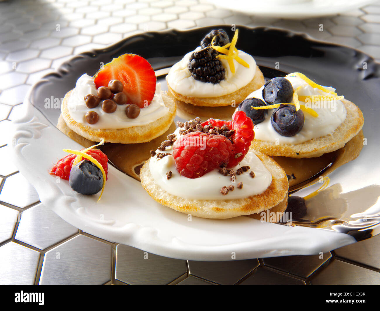 Süße blinis Canipe, Blini gekrönt mit Creme fraiche, Erdbeer und Schokolade und frischen Blaubeeren Stockfoto