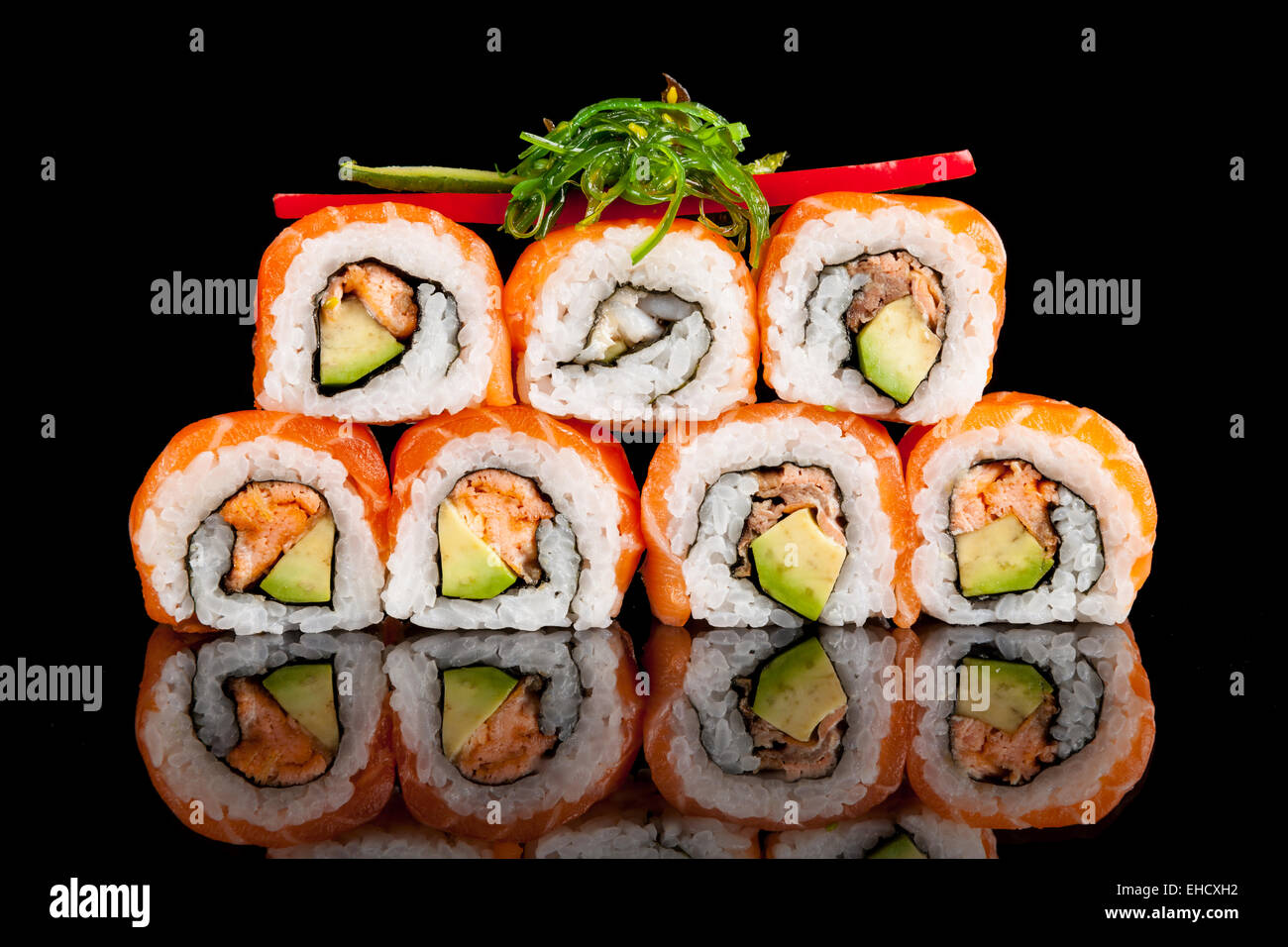 Auf schwarzen Tisch serviert köstliche Sushi-Rollen Stockfoto