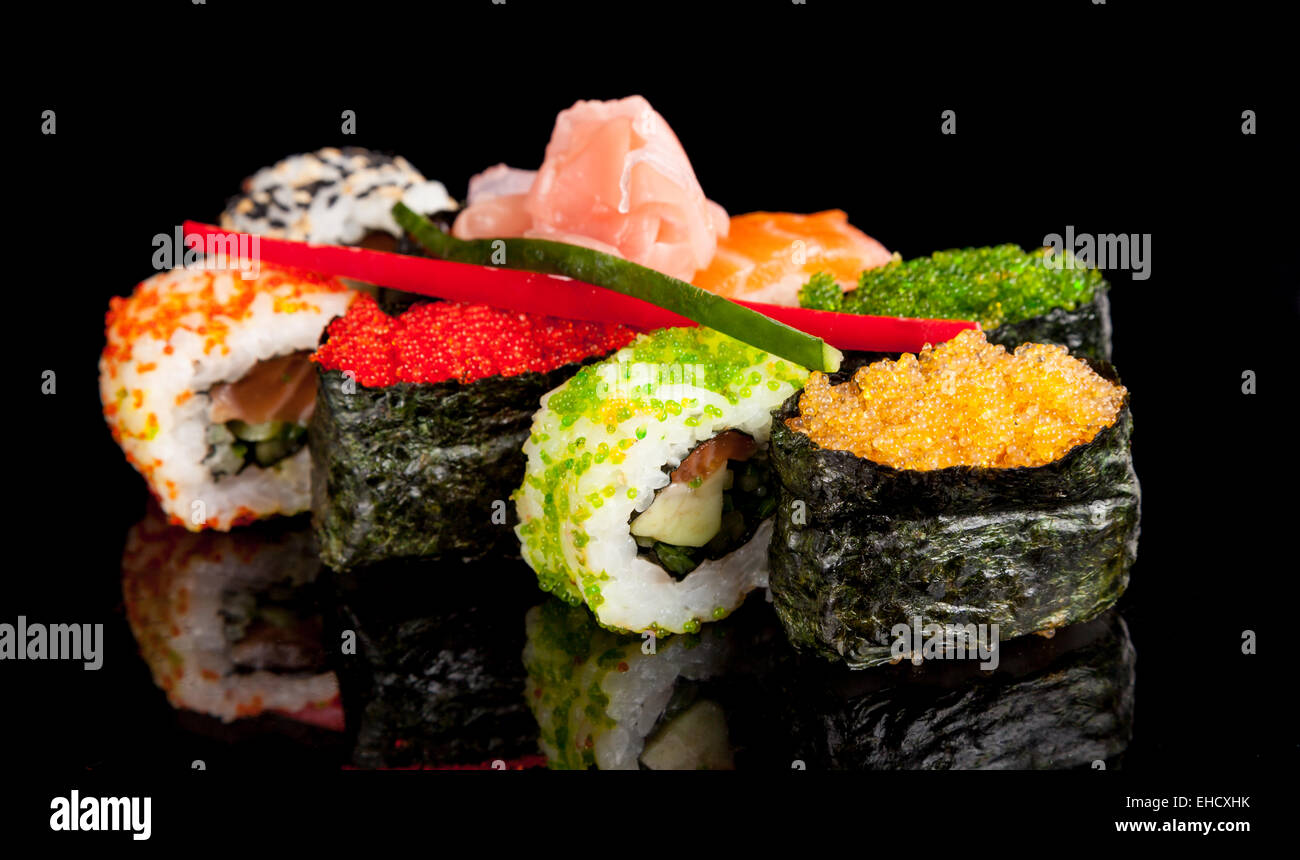 Auf schwarzen Tisch serviert köstliche Sushi-Rollen Stockfoto