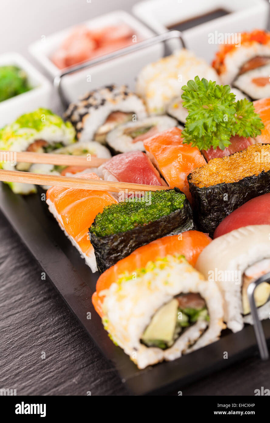 Auf schwarzen Teller und Stein serviert köstliche Sushi-Rollen Stockfoto