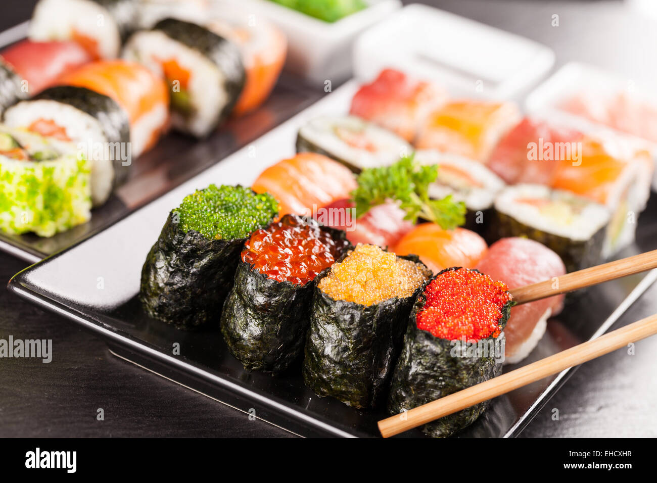 Auf schwarzen Teller und Stein serviert köstliche Sushi-Rollen Stockfoto