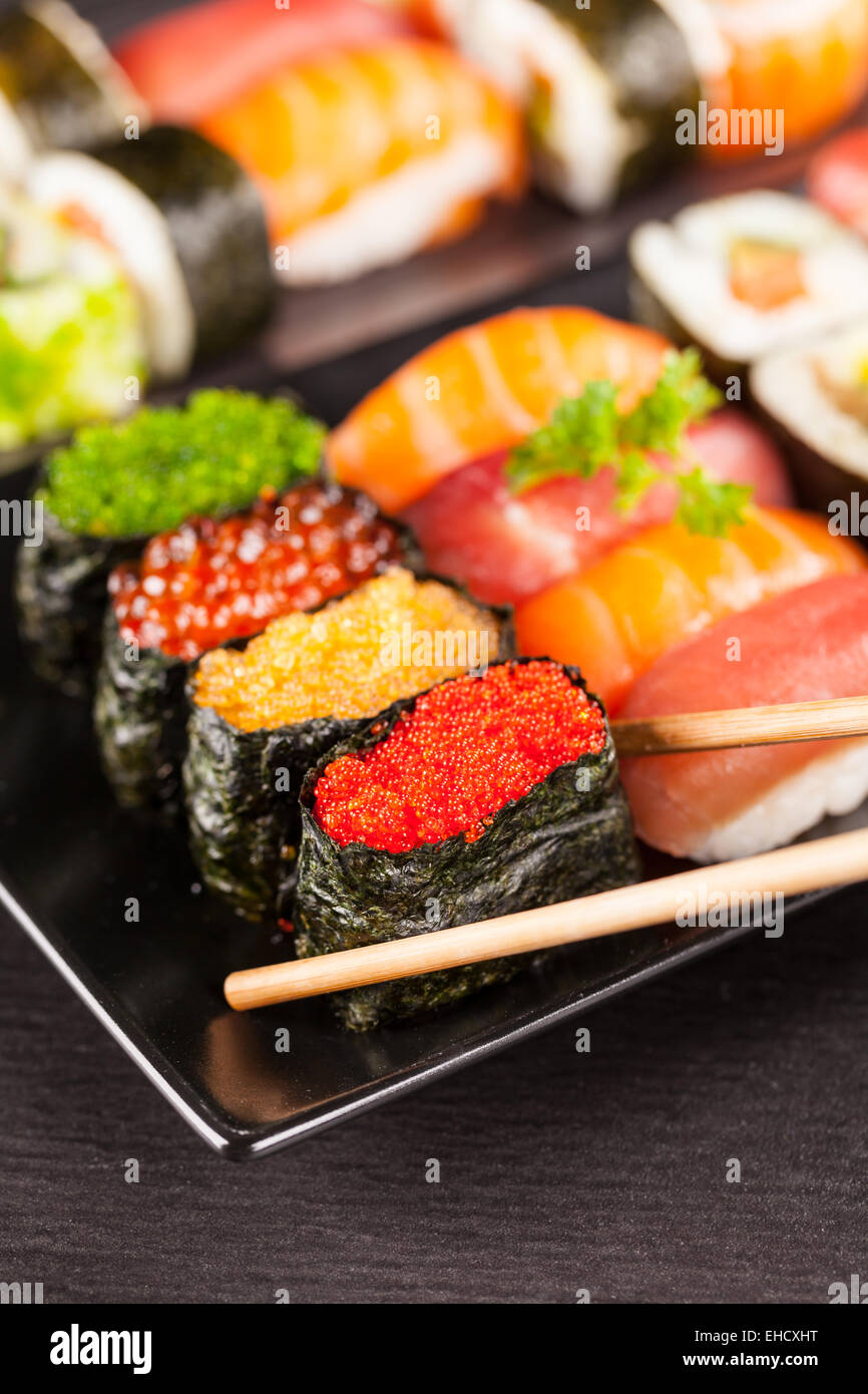 Auf schwarzen Teller und Stein serviert köstliche Sushi-Rollen Stockfoto